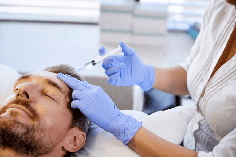 a man receives Botox injections on his forehead 